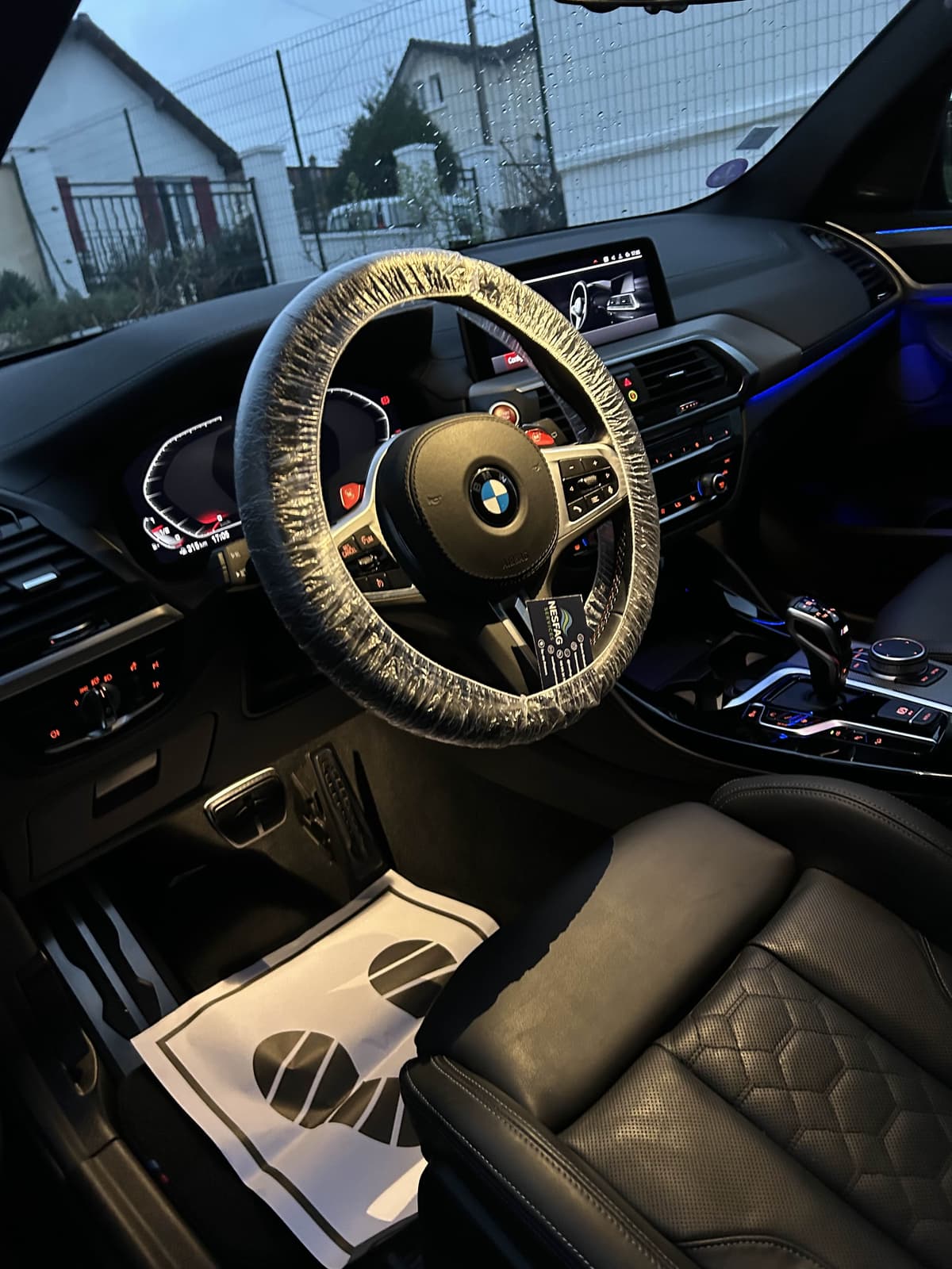 Nettoyage intérieur d'une BMW M5 avec volant protégé et tapis jetable, prestation premium Nesfag Services