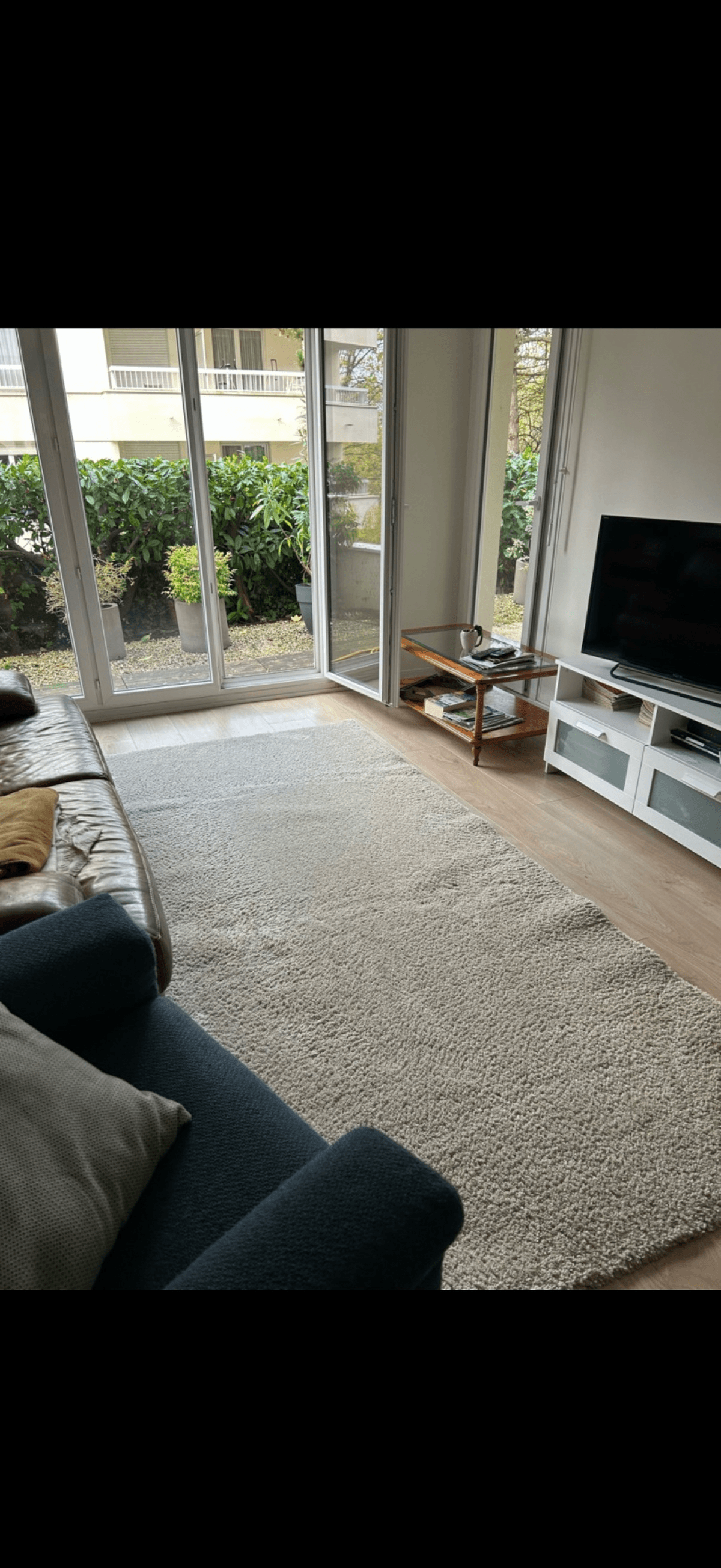Salon résidentiel avec grand tapis blanc shaggy nettoyé par Nesfag Services en Île-de-France