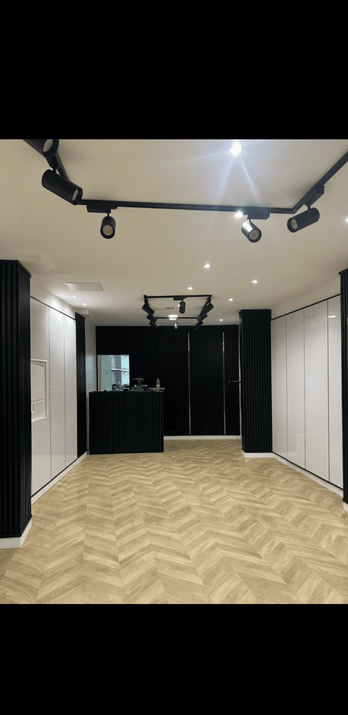 Local commercial remis en état par Nesfag Services avec parquet chevrons et éclairage sur rail